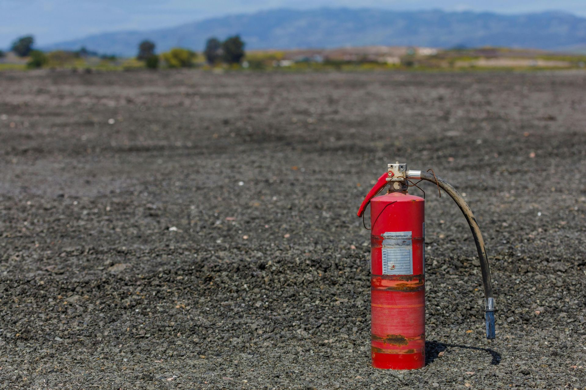 Rusty Fire Extinguisher on the Ground